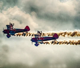 En el cielo de Barcelona, no sólo hacer acrobacias los aviones. En ediciones anteriores de la Merçe. Dos aviones biplanos volando en paralelo y con dos acróbatas encima de una de las alas.