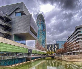 La plaça de les Glories, entre otros edificios, se encuentran dos muy emblemáticos, el DHub, Disseny Hub Barcelona (a la izquierda) y la Torre Glóries (antes Torre Agbar al fondo), sin contar que también se encuentran los Encantes de Barcelona, lugar donde algunos días de la semana se venden artículos antiguos o de ocasión. Edificos emblemáticos en la plaça de les Glories en Barcelona