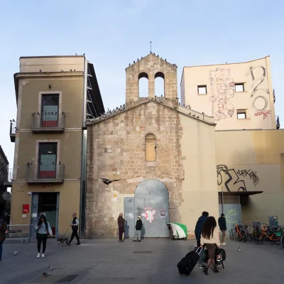 La iglesia, construida a finales del siglo XII, es de una sola nave con cabecera semicircular. La vuelta de cañón no es la original, fue sustituida a principios del siglo XVIII, la misma época en que se añadió una capilla cuadrada en el lado sur, el que da a la calle Hospital. En 1913 se le dio uso civil y sufrió importantes desperfectos, hasta que el Ayuntamiento la volvió a recuperar. capilla románica de Sant Llàtzer que preside la plaza del Pedró.