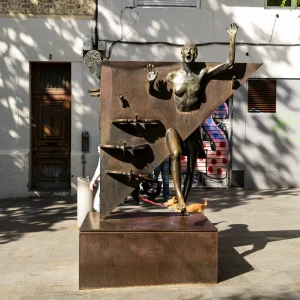 La escultura quiere representar una época que retrata a la perfección la obra de Rodoreda, que nos detalla (valiéndose de la técnica del monólogo interior) los sentimientos más profundos de una mujer inocente y sincera, a la que le tocará vivir la realidad de los años de la Segunda República, la Guerra Civil y la posguerra. La Colometa, la escultura de Xavier Medina-Campeny, realizada en bronce y acero corten, está ubicada en la plaza desde 1984.