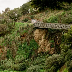 Espectacular puente de más de 261 metros de altura, es desconocido para muchos vecinos. Se trata del puente de Mühlberg, una construcción que conecta la calle con el mismo nombre y el parque del Guinardó (barrio de Can Baró). Cuenta con 70 metros de largo y se construyó en 1991. Con cerca de 70 metros de longitud, el puente de Mühlberg se instaló para salvar el hueco que hay en la pared del Turó de la Rovira