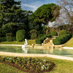 Detrás de un muro de 250 metros de largo rebosante de buganvillas, hay uno de los jardines más señoriales de Barcelona: los del Palacio Real de Pedralbes. Tanto afrancesados como ingleses, un punto románticos y muy frondosos, lo cierto es que adentrarse en ellos nos transporta a un tiempo en el que la serenidad y la majestuosidad fueron elementos determinantes del paisaje. Uno de los jardines más señoriales de Barcelona, tanto afrancesados como ingleses, un punto románticos y muy frondosos.