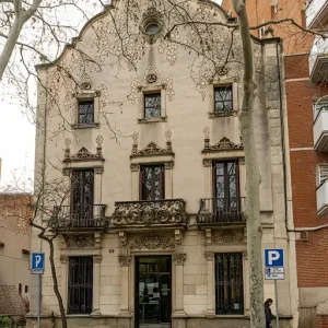 Can Guardiola, ubicado en la esquina de la calle de Cuba con la rambla de Fabra i Puig, en Sant Andreu, es un edificio que destaca por su singular y original fachada principal inspirada en las iglesias barrocas catalanas y los balcones de piedra esculpida que evocan el estilo plateresco barcelonés. Este edificio, construido en 1904, es un claro ejemplo de la influencia del modernismo en la Barcelona de principios del siglo XX. Su fachada recuerda a las creaciones de arquitectos como Puig i Cadafalch, y su interior alberga un universo de detalles que son testimonio de su época y de una gran riqueza creativa. Can Guardiola no solo es un maravilla arquitectónica, sino que también se ha convertido en un hotel de entidades, apoyando asociaciones sin ánimo de lucro y con finalidades sociales. Proyectada por el maestro de obras Josep Codina i Clapés y completada en el año 1904, Can Guardiola era originariamente una residencia unifamiliar con planta baja, dos pisos y buhardilla.