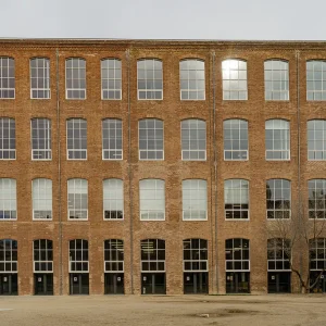La historia de Fabra i Coats comienza en 1837, cuando se fundó como El Vapor de Fil por Ferran Puig y Gibert. La fábrica se convirtió en un símbolo del cambio de una sociedad agrícola a una destinada a la industria. En 1903, se fusionó con la multinacional escocesa Coats, convirtiéndose en un pionero en Europa en la fabricación de hilos y tejidos. La fábrica llegó a tener 9 fábricas en Cataluña y 52 en otros países, y era un espacio innovador con prestaciones sociales para sus trabajadores. La fábrica cerró sus puertas en 2005, pero su historia y legado han sido preservados y transformados en un Centro de Arte Contemporáneo y cultural. Fabra i Coats es un espacio de creatividad y talento, que sigue siendo un punto clave para entender la historia y la cultura de Barcelona.