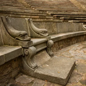 Está ubicado en una antigua cantera de la montaña, cuya pared cortada hace la función de escena del teatro. La superficie es de 460 m² y tiene un aforo de 1.900 espectadores. Junto al teatro hay unos jardines, diseñados por Rubió y Tudurí y Jean-Claude Nicolas Forestier, así como un pabellón que inicialmente estaba diseñado para conciertos musicales y hoy es un restaurante El Teatre Grec es un teatro al aire libre en Barcelona, situado en la calle Santa Madrona de Barcelona, en la montaña de Montjuïc.