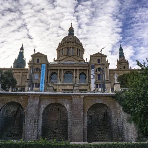 El Museu Nacional d'Art de Catalunya está ubicado en el Palau Nacional de Montjuïc, construido para la Exposición Internacional de 1929. En 1934 abrió sus puertas como Museu d'Art de Catalunya, reuniendo la colección medieval. Posteriormente, en 1995, ya como Museu Nacional d'Art de Catalunya, se inauguran las salas nuevas de arte románico y de manera sucesiva se va ampliando la exhibición pública de los fondos, proceso que culmina en 2004 con la nueva presentación de arte moderno. <a href="https://www.museunacional.cat/es/descripcion-breve" target="_blank">Fuente : Museu Nacional d'Art de Catalunya.</a> el MNAC, está situado en la montaña de Montjuïc, un entorno privilegiado desde el cual se puede disfrutar de una magnífica y única vista de Barcelona.