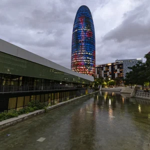 El monolito cilíndrico y brillante que refleja los colores de Barcelona se ha ganado un espacio en la silueta de la ciudad. La Torre Glòries es un homenaje del arquitecto Jean Nouvel a la arquitectura de Antoni Gaudí, que se ha convertido en un símbolo de la Barcelona contemporánea. El mirador, que se podrá visitar a partir del 20 de mayo, ofrece unas vistas únicas de 360° sobre la ciudad, a 125 metros de altura.
<a href="https://www.barcelona.cat/es/conocebcn/pics/la-torre-agbar-99400077221" target="_blank">Fuente : Ajuntament de Barcelona</a> Jean Nouvel se inspiró en las formas redondeadas de las montañas de Montserrat y en los pináculos de la Sagrada Familia para proyectar la torre.